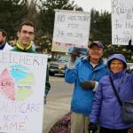 From left, Kyle Callahan of Sammamish and Bob and Evelyn Melton of Sammamish braved the rain to say that they don&rsquo;t want 24 million people to lose health coverage. Nicole Jennings/staff photo