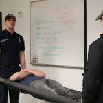 Eastside Fire and Rescue Firefighter Mike Webb demonstrates how to create a makeshift stretcher using two metal poles and a blanket. Nicole Jennings/staff photo