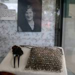 A hair pin and sparkly purse sit in front of a photo of flapper Alpha (last name unknown). Purses not only served a function, but also were used as a bold fashion statement. Nicole Jennings/staff photo