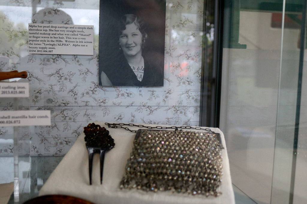 A hair pin and sparkly purse sit in front of a photo of flapper Alpha (last name unknown). Purses not only served a function, but also were used as a bold fashion statement. Nicole Jennings/staff photo