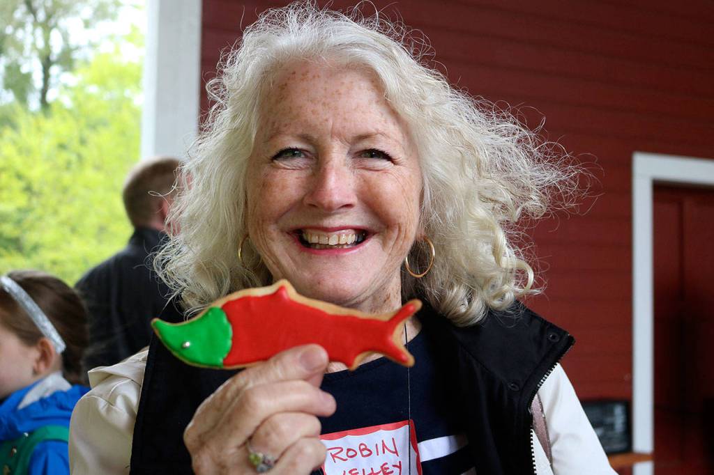 Robin Kelley, executive director of Friends of the Issaquah Salmon Hatchery (FISH) holds up a cookie in the shape of the fish she works to save. Nicole Jennings/staff photo