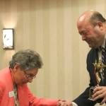 Issaquah Chamber of Commerce Citizen of the Year winner Karen Ridlon is helped onstage by Chamber Board President David Bleiweiss. Nicole Jennings/staff photo