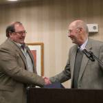 Issaquah Mayor Fred Butler welcomes Joe Forkner into the city&rsquo;s Hall of Fame with a hearty handshake. Nicole Jennings/staff photo