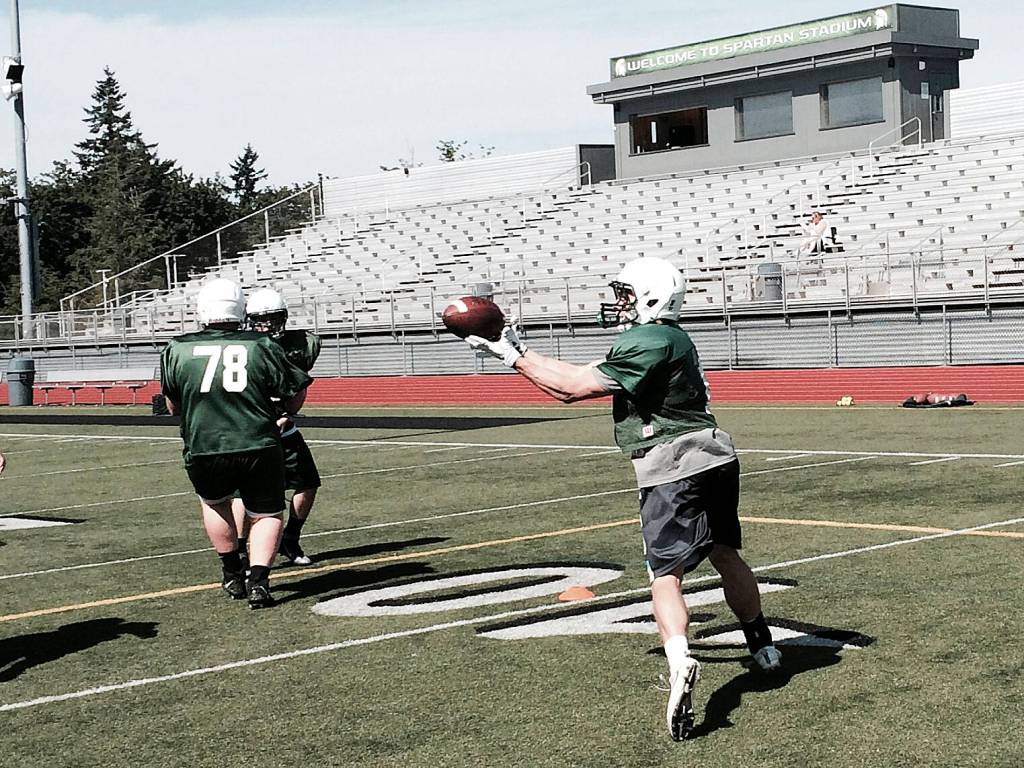 Shaun Scott, staff photo                                Skyline Spartans running back Carson Clark, right, hauls in a pass in the flat during a spring football practice session on June 6 at Skyline High School in Sammamish.