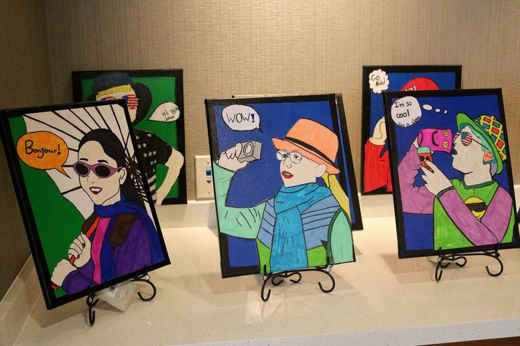 The pictures depict the students themselves doing everyday activities, such as taking photos and drinking Cola. Nicole Jennings/staff photo