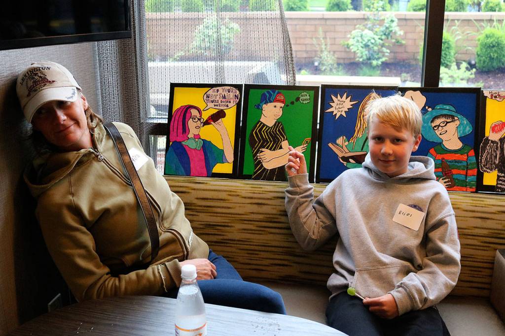 Clark fourth grader Elias Saarela points to the picture he created while his mom Mira looks on. Nicole Jennings/staff photo