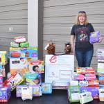 An employee of Redmond-based Nintendo of America shows off the company&rsquo;s collection of diapers that employees donated for Eastside Baby Corner&rsquo;s annual Diaper Derby. Contributed photo