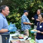 Former Chamber of Commerce Board President Alan Finkelstein serves up tasty hamburgers and chicken burgers as he gets to know Dr. Diana Wu, D.D.S., who will be opening up a dental clinic in Issaquah next month.