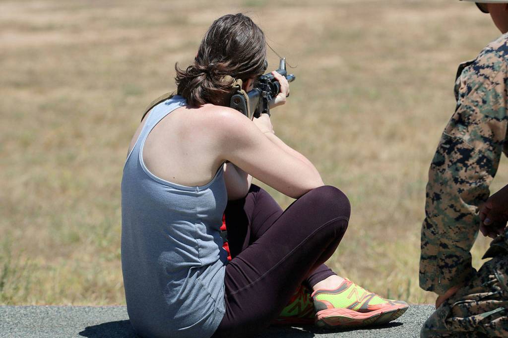 Bethany Shoda, who teaches history at Lake Washington High School in Kirkland, takes aim with an M16 assault rifle. Nicole Jennings/staff photo