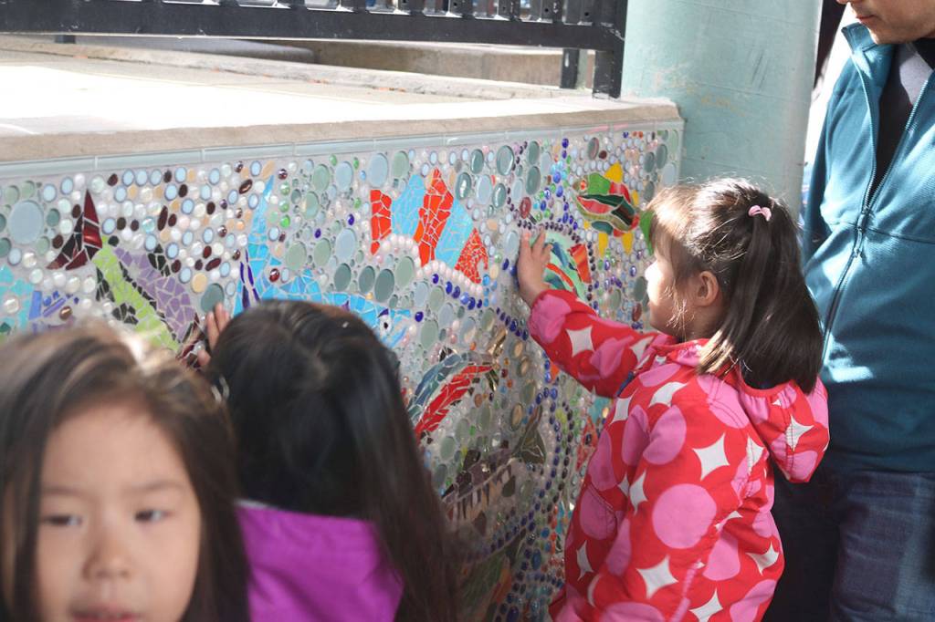 Children admire the new community-made mural at the Issaquah Salmon Hatchery.