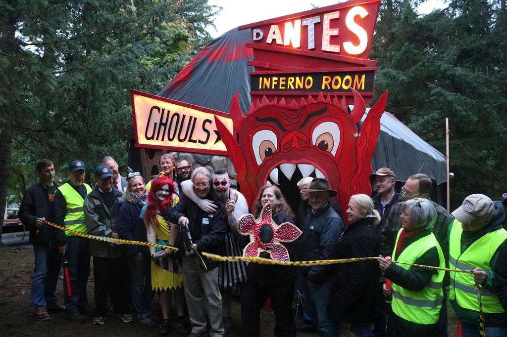 Surrounded by Sammamish Rotary and Scare Productions, Inc. volunteers, Sammamish Mayor Bob Keller, center, cuts the ribbon and opens Nightmare at Beaver Lake 2017. Nicole Jennings/staff photo