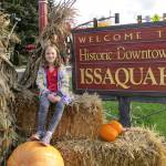 A girl gets her photo taken while sitting on a bale of hay during the 2016 Issaquah Goes Apples event. Courtesy photo