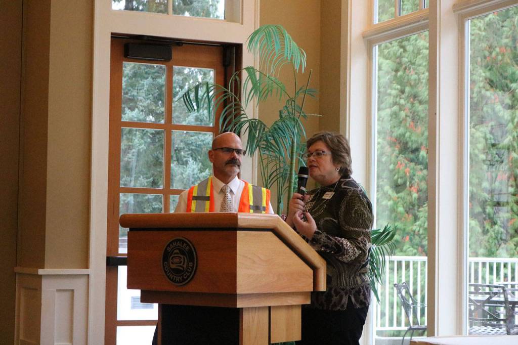Sogge gives outgoing chamber board President Craig Doty, left, the President&rsquo;s Award for his time with the chamber. He wears a traffic safety vest to symbolize his volunteer work as a traffic director at the Sammamish Farmers Market. Nicole Jennings/staff photo