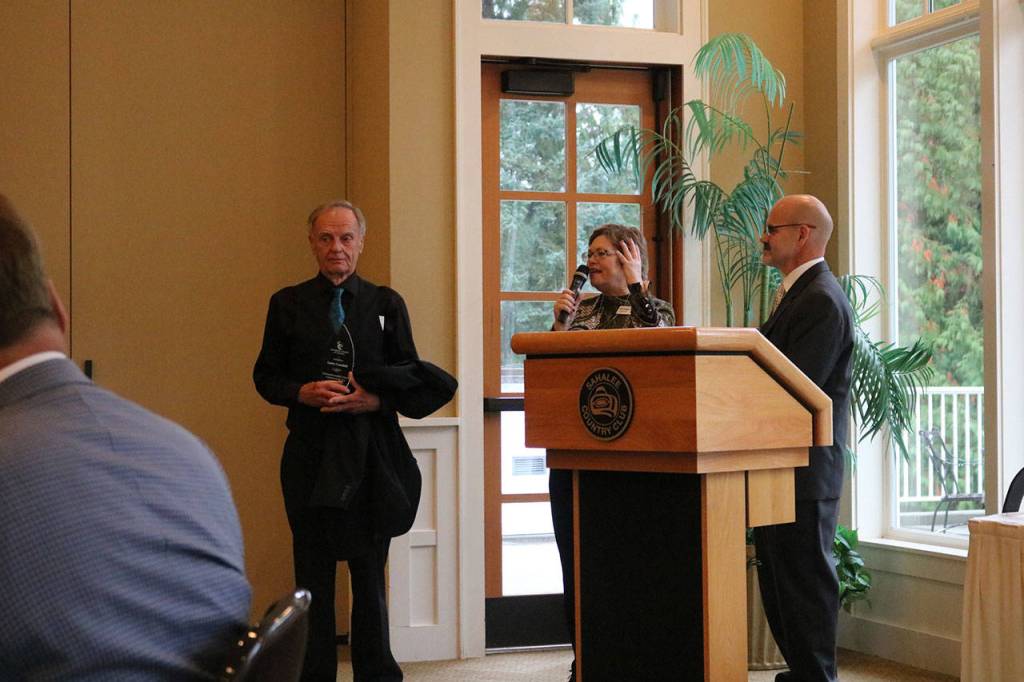 Larry Crandall, left, receives the Sammamish Farmers Market Volunteer Award from Sogge and Doty. Nicole Jennings/staff photo