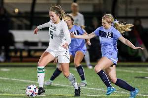 Photo courtesy of Rick Edelman/Rick Edelman Photography                                The Skyline Spartans girls soccer team registered a 2-0 victory against the Rogers Rams in the first round of the Class 4A state playoffs on Nov. 8 at Skyline High School in Sammamish. Skyline senior midfielder McKenna Ross, left, dribbled the ball down the field while being chased by a Rams player.