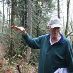Save Cougar Mountain member David Kappler points out where a road with a grade of 12 percent will have to be cut into the hillside. Nicole Jennings/staff photo