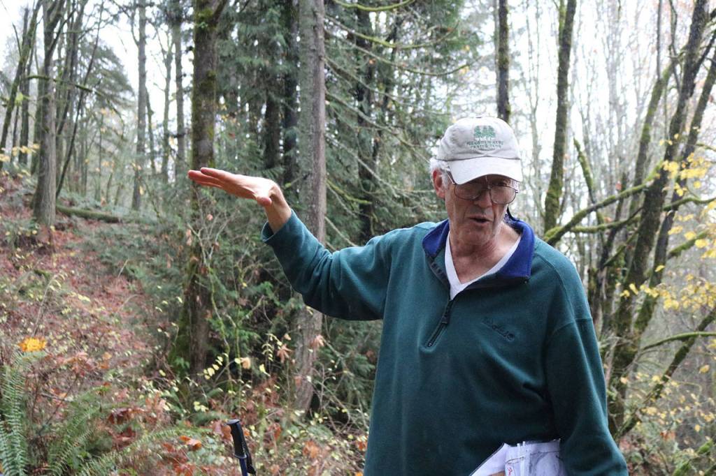 Save Cougar Mountain member David Kappler points out where a road with a grade of 12 percent will have to be cut into the hillside. Nicole Jennings/staff photo