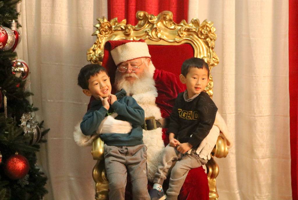 Yuta and Sota Hidaka get a picture with Santa Claus. (Evan Pappas/Staff Photo)
