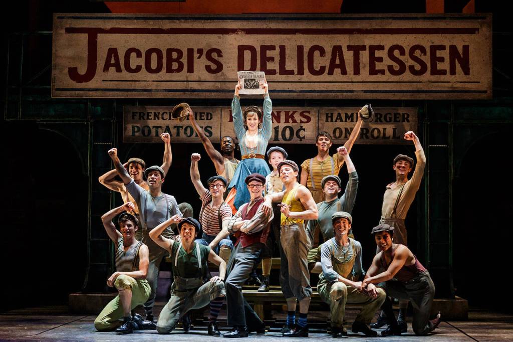 The Newsies and Katherine celebrate their first cover story. Photo courtesy of Village Theatre