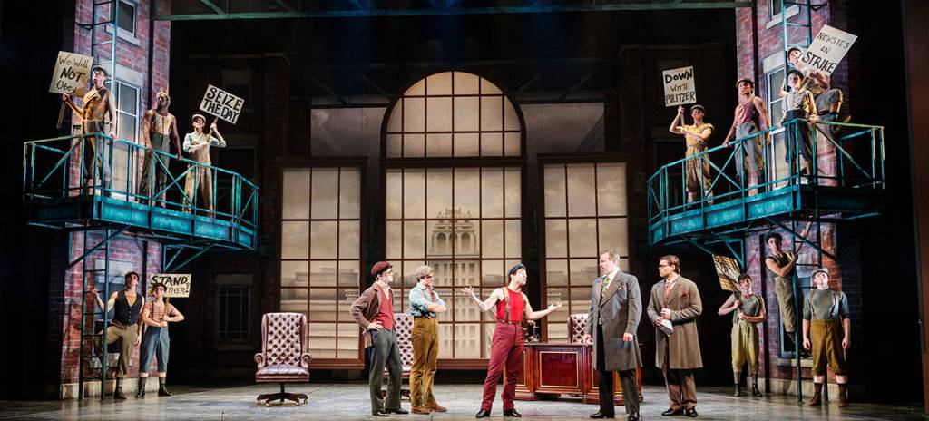 The Newsies bravely stand up to Pulitzer, who promises to have them all beaten and arrested if they do not call off the strike. Photo courtesy of Village Theatre