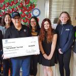 Representatives from The Garage A Teen café accept a check from the Kiwanis Club of Issaquah. From left, Julia Imler, Dylan Kostadinov, Executive Director KayLee Jaech, Kiwanis President Ruben Nieto, Lisa Lee, M Haynes, Olivia Van Ry, Evon Mahesh. Photo courtesy of the Kiwanis Club of Issaquah