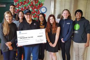 Representatives from The Garage A Teen café accept a check from the Kiwanis Club of Issaquah. From left, Julia Imler, Dylan Kostadinov, Executive Director KayLee Jaech, Kiwanis President Ruben Nieto, Lisa Lee, M Haynes, Olivia Van Ry, Evon Mahesh. Photo courtesy of the Kiwanis Club of Issaquah