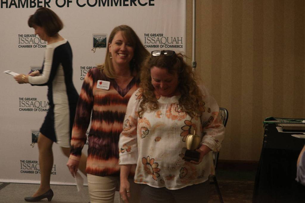 Kim Weiss, right, holds her Golden Apple Award from the Issaquah Schools Foundation as she returns to her seat. Aaron Kunkler/Staff photo