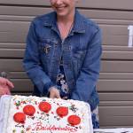Erin Hansman poses for a picture with a cake with the message #baldforbabies on it. Photo courtesy of Eastside Baby Corner