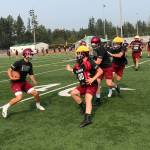 Eastlake Wolves quarterback Jackson Proctor, left, scrambles for extra yardage during the second day of practice on Aug. 16 in Sammamish. Shaun Scott/staff photo