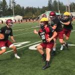 Eastlake Wolves quarterback Jackson Proctor, left, scrambles for extra yardage during the second day of practice on Aug. 16 in Sammamish. Shaun Scott/staff photo