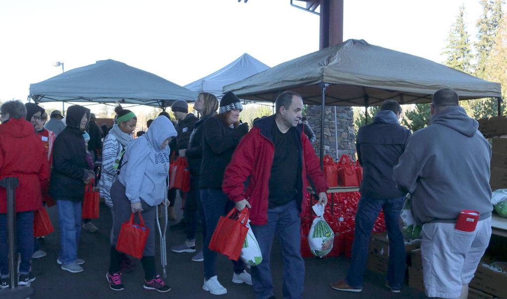 People lined up around Eastridge Church in Issaquah for the turkey giveaway. Additional food items, such as stuffing, were also included in red bags as well. Evan Pappas/Staff Photo
