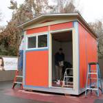 Volunteers work on painting and finishing the tiny house before it is donated to the Low Income Housing Institutes newest village in Olympia. Evan Pappas/Staff Photo