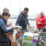 Volunteer Marcus Cannon helps an Issaquah shopper sort and load her donation to the Coast Guard pantry. Evan Pappas/Staff Photo