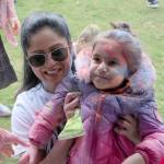 Priyanka Pathak lifts her daughter Dia to the stage to get some Holi color. Evan Pappas/Staff Photo