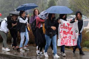 IHS students walkout to protest racist post on Wednesday with a sign that says Change is More Than a ReTweet. Madison Miller / staff photo