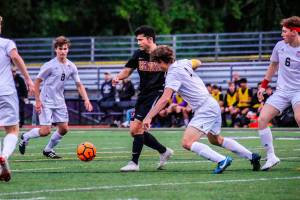 Issaquah Eagles senior Taiga Crenshaw (No. 10) is surrounded by a bevy of Mount Si Wildcats players in the 4A state quarterfinals on May 18 at Gary Moore Stadium in Issaquah. Photo courtesy of Don Borin/Stop Action Photography