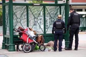 Redmond Police Officers and Kroll (not pictured) make contact with an individual sleeping at the downtown park and ride center. Ashley Hiruko/staff photo