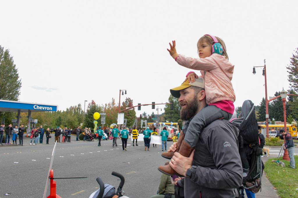 Natalie DeFord/staff photo                                3-year-old Sylvie watches the Salmon Days Oct. 5 Grande Parade from atop Corey Derrs shoulders, waving at all the princesses.