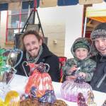 Brockman Guinee, John Ezell and John Jr. at the Art by Fire table during the Issaquah Goes Apples fair Oct. 19, selling glass blown pumpkins and apples. Natalie DeFord/Staff photo