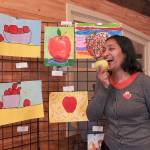 Ekta Gupta, local artist and art instructor, posing in front of the submissions to this years Apple Art Competition at the Oct. 19 Issaquah Goes Apples fair. Natalie DeFord/staff photo