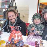 Brockman Guinee, John Ezell and John Jr. at the Art by Fire table during the Issaquah Goes Apples fair Oct. 19, selling glass blown pumpkins and apples. Natalie DeFord/Staff photo