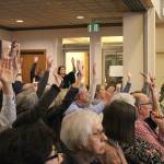 Re-zoning supporters raise hands in support of a speaker at the Nov. 12 council study session. Madison Miller / staff photo