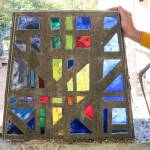 Nicholas Frei holds up a segment of one of the Providence Heights College chapels 14 windows. Each window has 38 segments, so more than 500 segments had to be deconstructed, packaged and catalogued. Courtesy of Sisters of Providence, Mother Joseph Province.