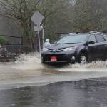 A car drives through flooding on the road outside the Issaquah Salmon Hatchery on Feb. 6, 2020. Mitchell Atencio/staff photo