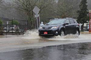 A car drives through flooding on the road outside the Issaquah Salmon Hatchery on Feb. 6, 2020. Mitchell Atencio/staff photo