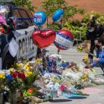 People place flowers at a memorial Tuesday in front of Bothell City Hall for a Bothell police officer who was killed Monday night. (Olivia Vanni / The Herald)