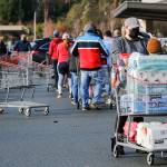 Costso customers unload groceries as the line to get in grows Sunday morning in Lynnwood. (Kevin Clark / The Herald)