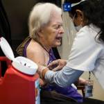 Jackie Hoernor, a resident at South Pointe Assisted Living, winces as she gets her Pfizer COVID-19 vaccination during a Walgreens Vaccine Clinic at South Pointe on Feb. 12 in Everett. (Olivia Vanni / The Herald)