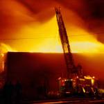 A ladder truck shoots water over the south wall of the Everett Community College library complex on Feb. 16, 1987. The arson destroyed the facility and killed Everett firefighter Gary Parks. (Michael OLeary / Herald file)