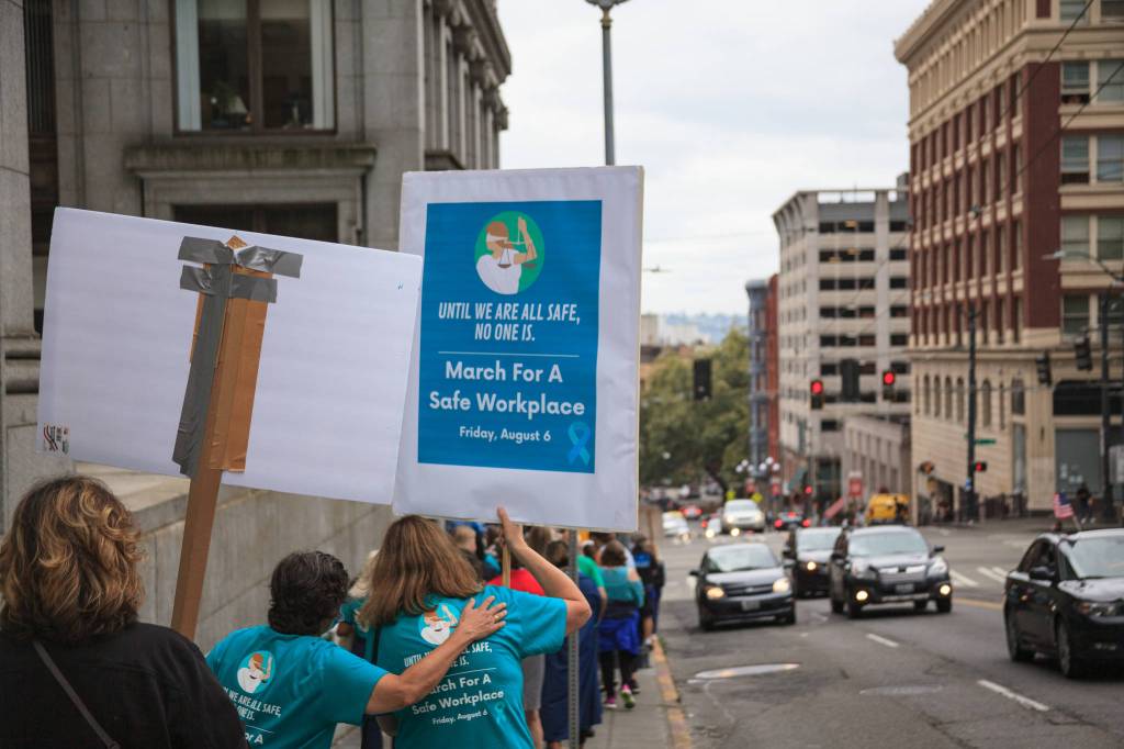 County employees and supporters walk around the block during a march for womens safety at work in Seattle on Friday, Aug. 6, 2021. The march was scheduled after a woman was attacked in a bathroom at the King County Courthouse. Photo by Henry Stewart-Wood/Sound Publishing